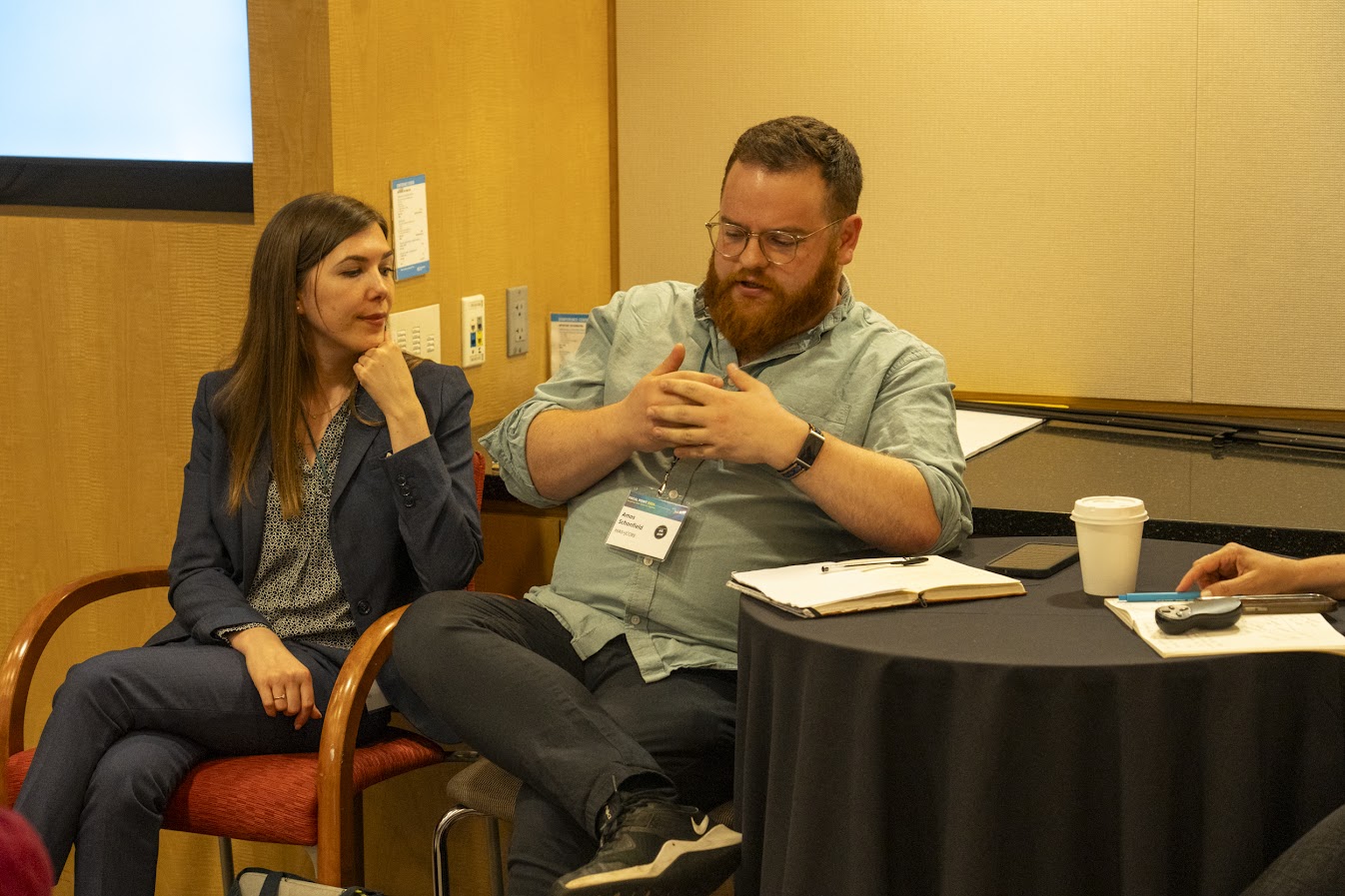 Amos Schonfield presents at a conference panel. He is seated next to Liora Jaffe, HIAS Europe.